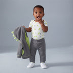 Bebé con conjunto EmpiBy de tres piezas: chaqueta gris con capucha de dragón, body estampado y pantalón a juego.