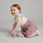 Bebé con conjunto EmpiBy de camiseta blanca acanalada con volantes y falda-short rosa con estampado floral