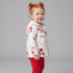 Niña pequeña con conjunto EmpiBy de chaqueta blanca con flores y mariquitas, body y leggings rojos de lunares
