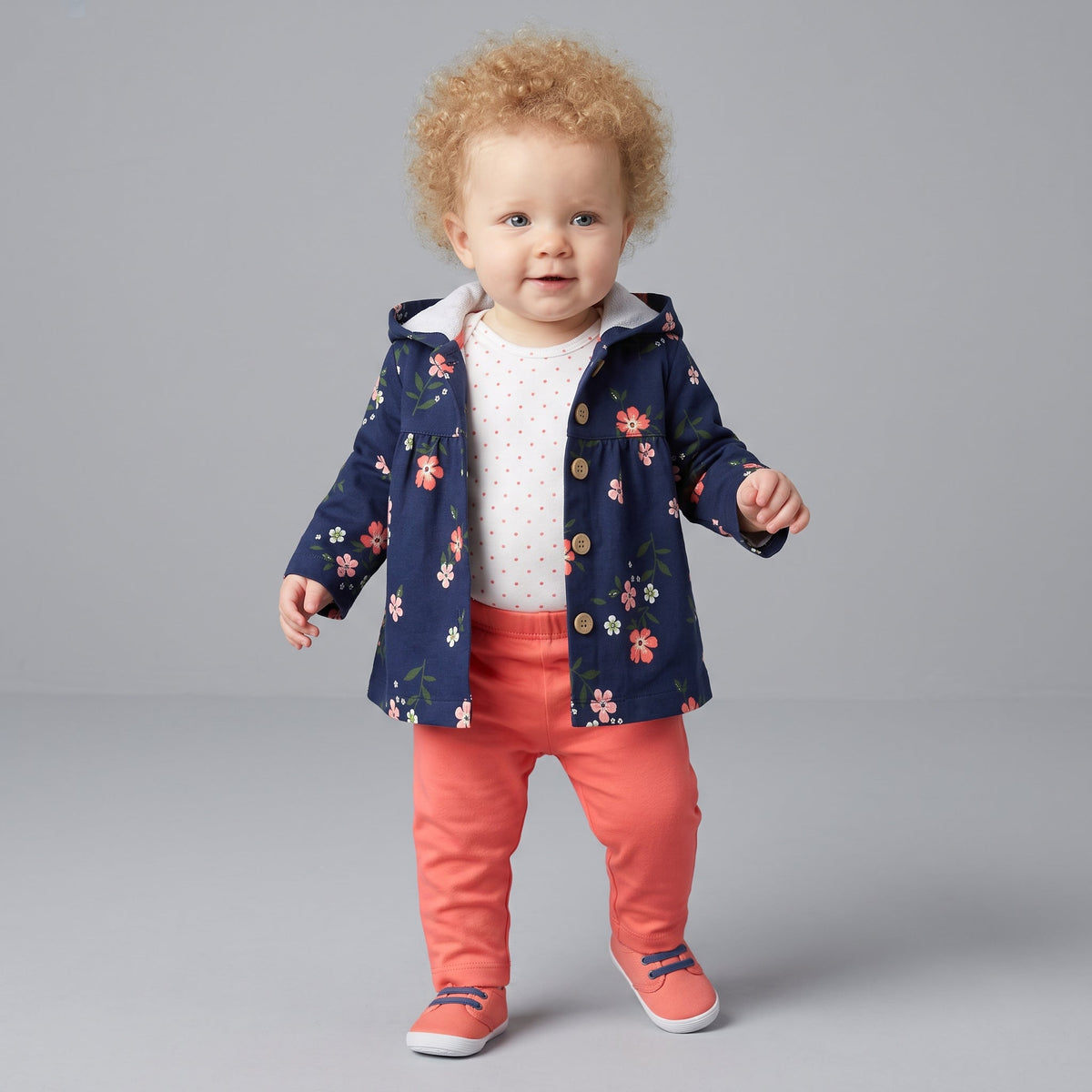 Bebé con conjunto EmpiBy de 3 piezas: chaqueta azul marino con flores, body blanco con lunares y pantalón rosa salmón