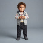 Bebé con conjunto EmpiBy de 3 piezas: chaleco gris con capucha de mapache, body a rayas y pantalón jean oscuro.