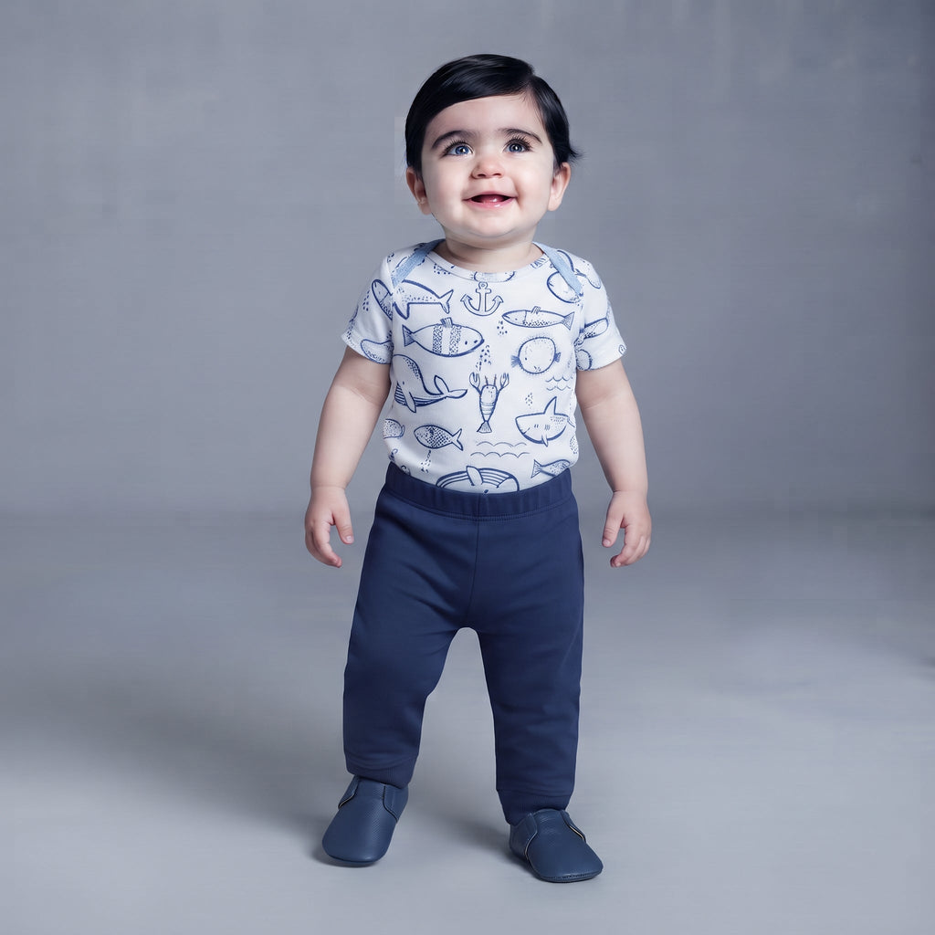 Bebé con body blanco estampado de vida marina y pantalón azul marino de EmpiBy, estilo casual y cómodo