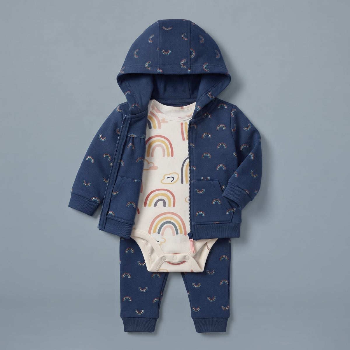 Conjunto EmpiBy de 3 piezas para bebé niña con chaqueta azul de arcoíris, body blanco y pantalón a juego.