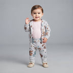Bebé niña vistiendo conjunto EmpiBy de tres piezas gris con estampado de ardillas, body rosa y chaqueta con capucha.