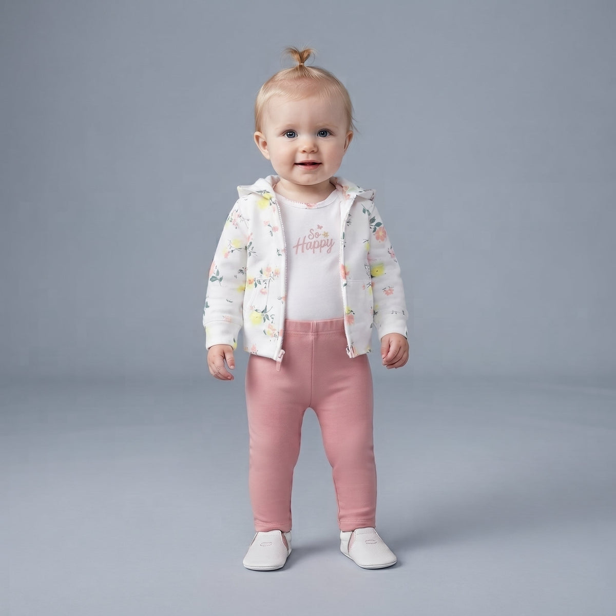Bebé niña vistiendo conjunto EmpiBy de 3 piezas: chaqueta floral, body blanco So Happy y legging rosa