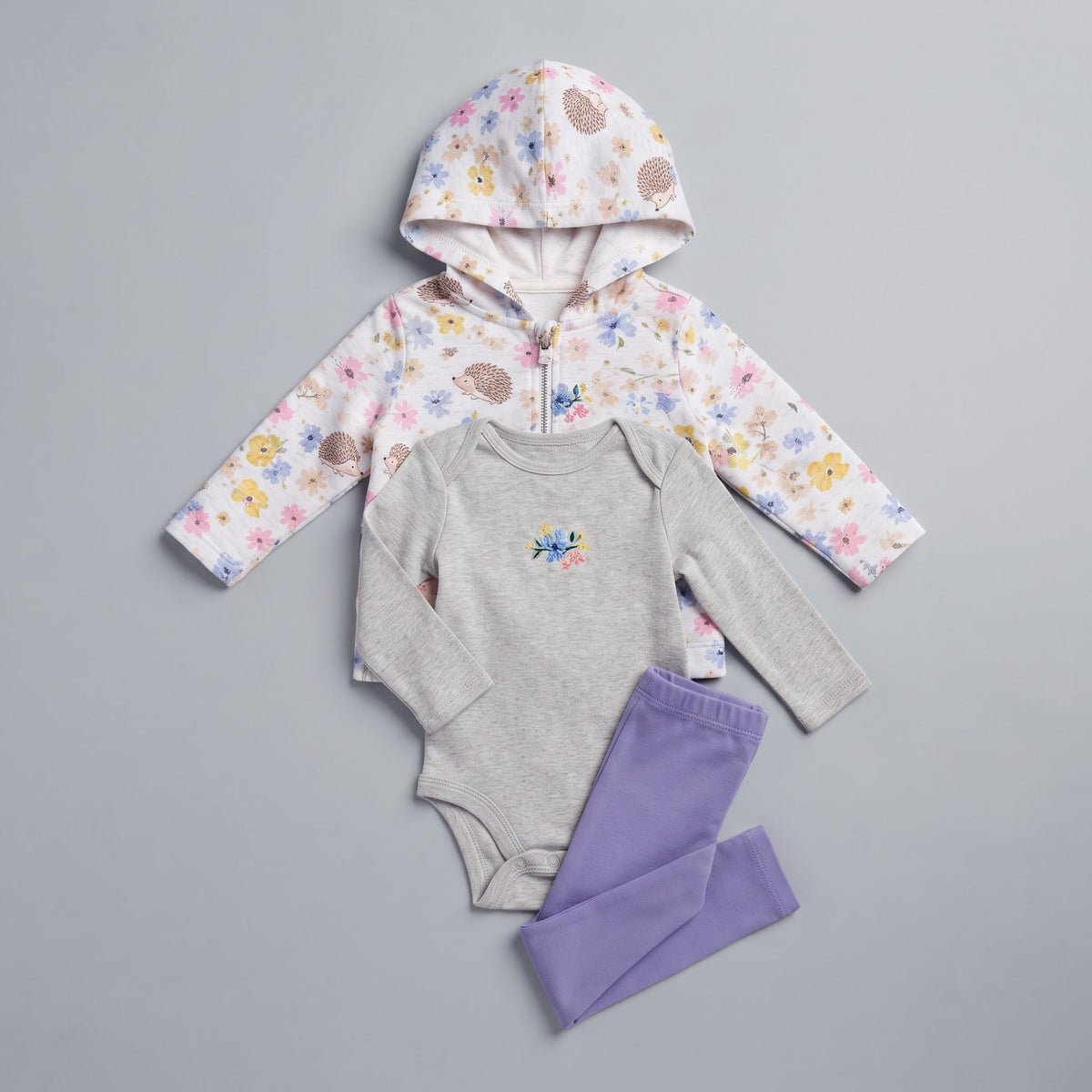Conjunto de 3 piezas EmpiBy para bebé niña con chaqueta floral, body gris bordado y legging morado elástico.