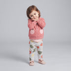 Niña pequeña con conjunto EmpiBy de 3 piezas: chaqueta rosa con lunares y bolsillos de manzana, body y pantalón gris