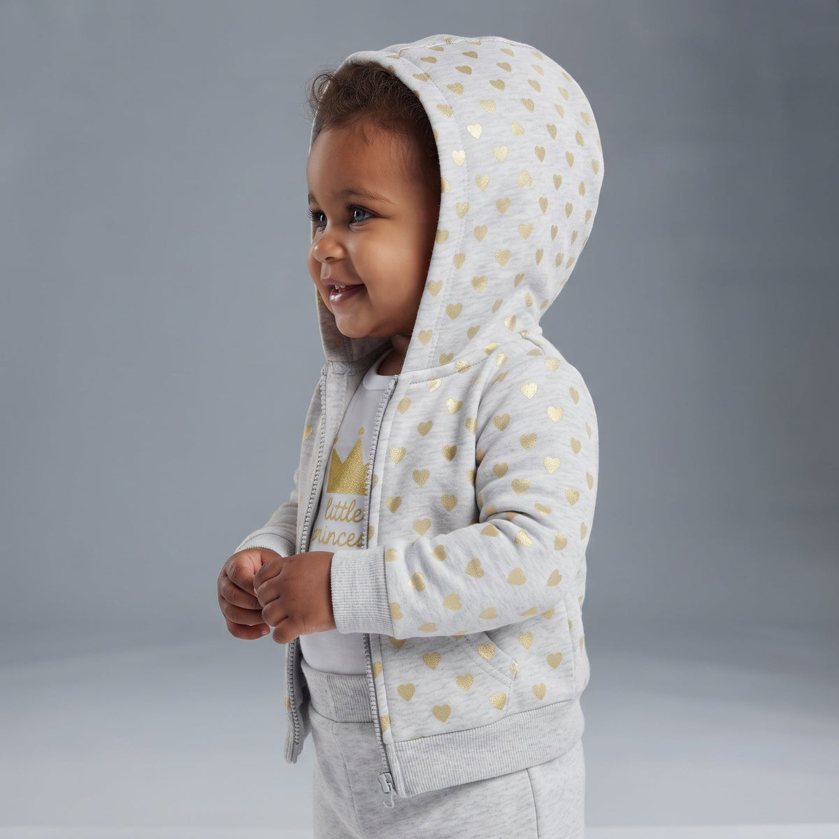 Bebé niña vistiendo conjunto EmpiBy de tres piezas gris con corazones dorados y chaqueta con capucha