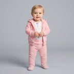 Bebé niña vistiendo conjunto EmpiBy de tres piezas rosa con chaqueta con capucha, body estampado y pantalón cómodo.