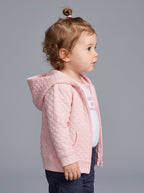 Niña pequeña con conjunto EmpiBy de 3 piezas: chaqueta rosa acolchada con capucha, body blanco y pantalón azul oscuro.
