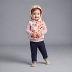 Niña pequeña con conjunto EmpiBy de 3 piezas: chaleco floral con capucha, body morado y pantalón tipo jean azul.
