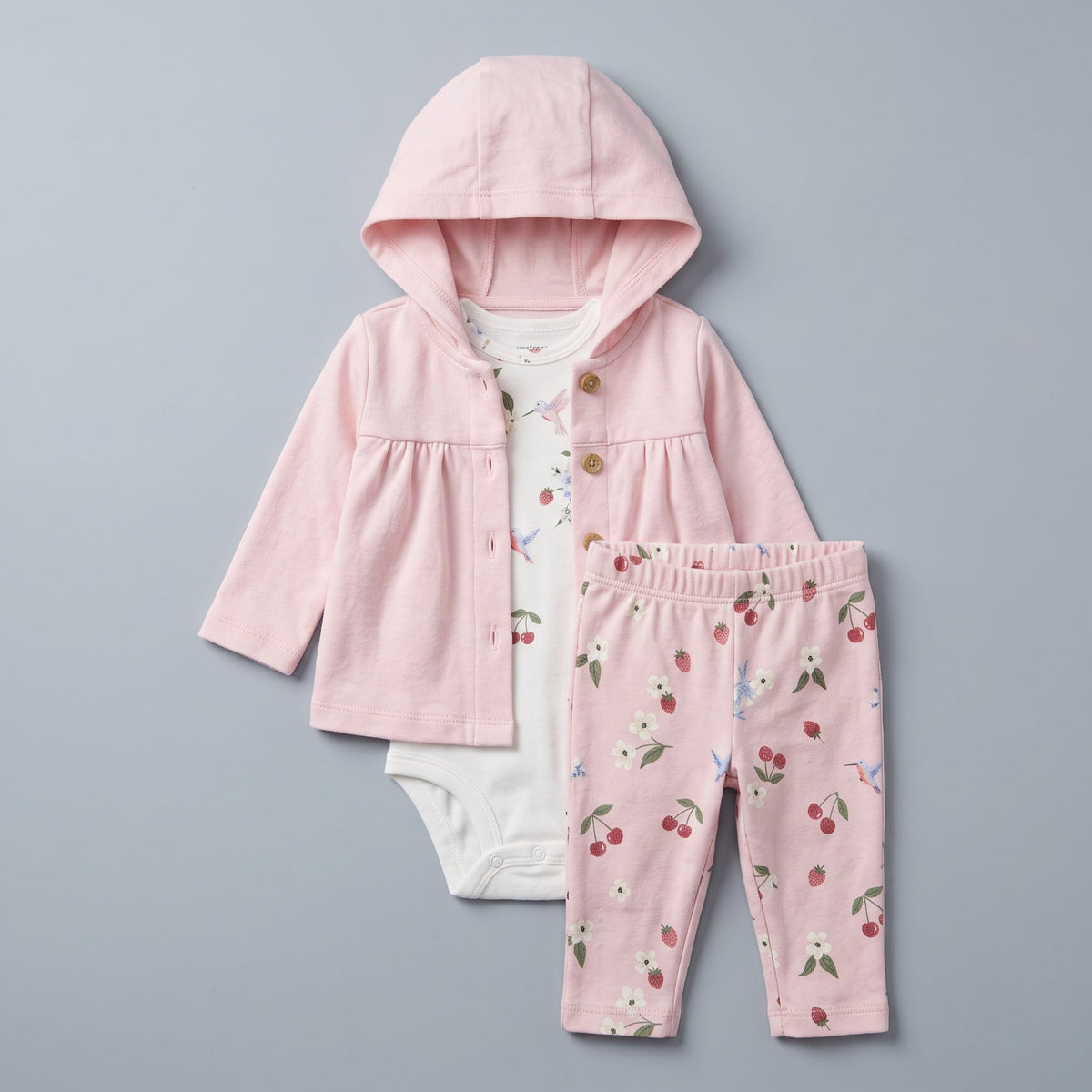 Conjunto EmpiBy de 3 piezas para bebé niña: chaqueta rosa con capucha, body blanco y legging estampado de frutas.