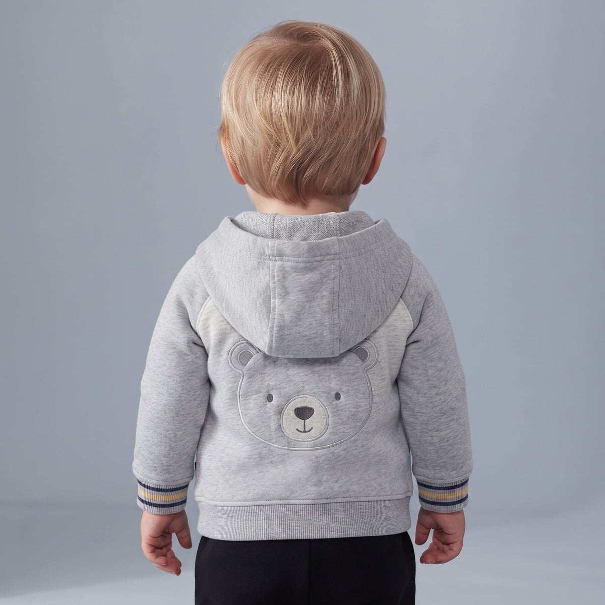 Conjunto EmpiBy de 3 piezas para bebé con chaqueta gris de osito, body estampado y pantalón negro, vista trasera.