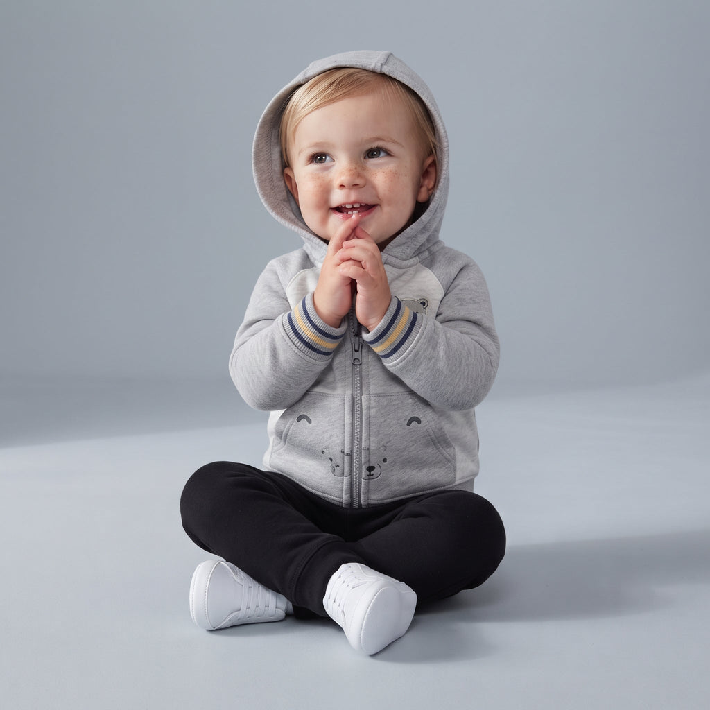Bebé con conjunto EmpiBy de 3 piezas: chaqueta gris con capucha de osito, body estampado y pantalón negro.