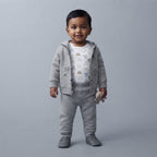 Bebé con conjunto EmpiBy de tres piezas gris: chaqueta con capucha de osito, body estampado y pantalón cómodo.