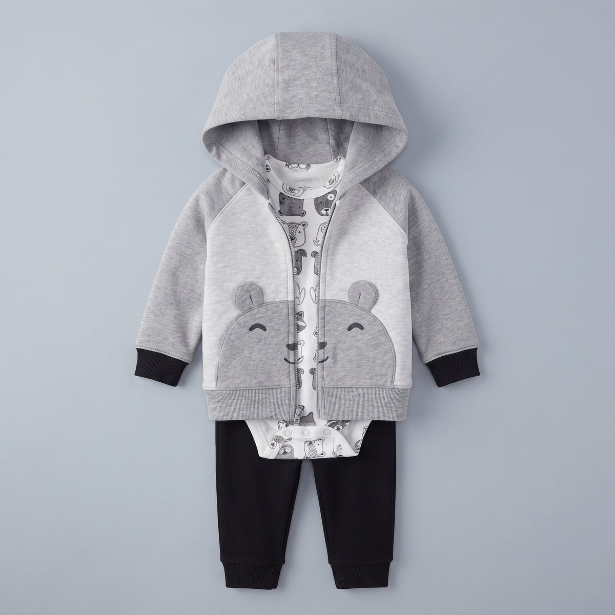 Conjunto EmpiBy de 3 piezas para bebé: chaqueta gris con capucha de osito, body blanco estampado y pantalón negro.