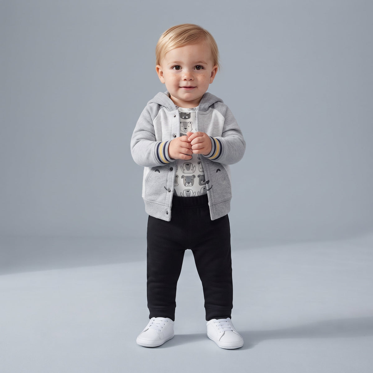 Conjunto EmpiBy de 3 piezas para bebé: chaqueta gris con capucha de osito, body estampado y pantalón negro.