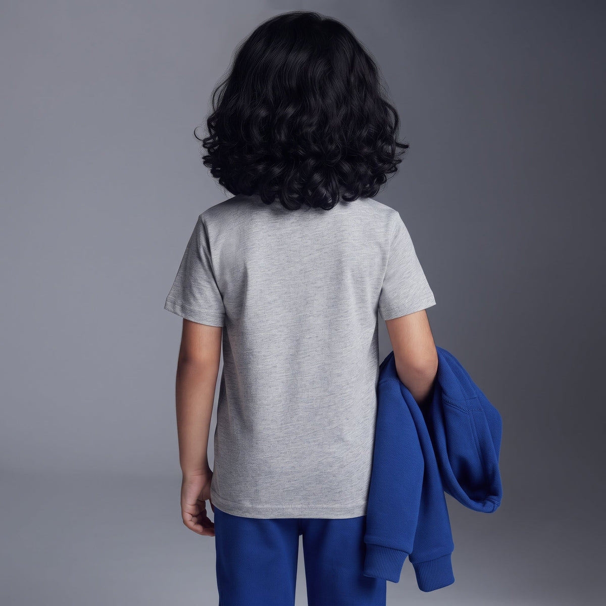Niño de espaldas vistiendo conjunto EmpiBy de Capitán América con camiseta gris, pantalón jogger y sudadera azul
