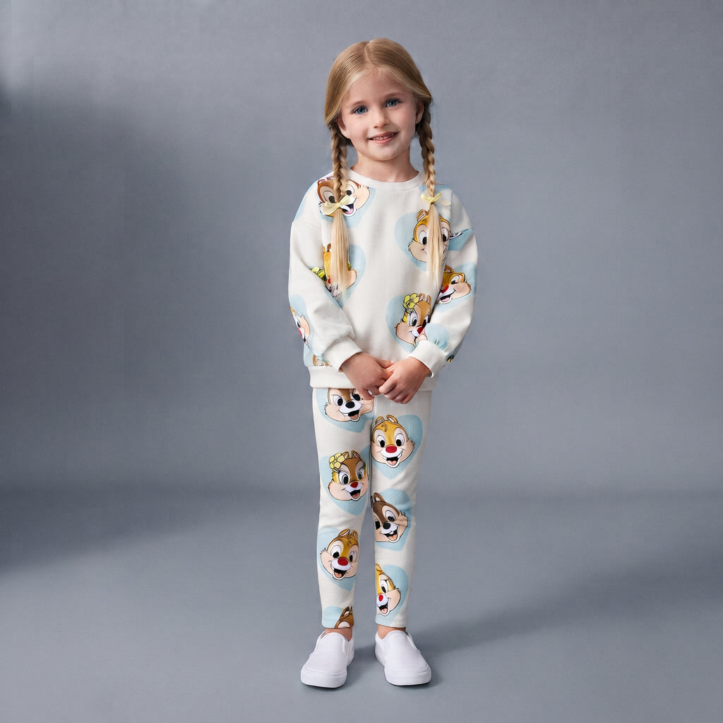 Niña con conjunto EmpiBy de dos piezas con estampado de Chip y Dale sobre corazones celestes y fondo claro.