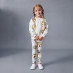 Niña con conjunto EmpiBy de dos piezas con estampado de Chip y Dale sobre corazones celestes y fondo claro.
