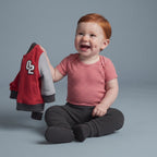 Bebé feliz con conjunto EmpiBy de 3 piezas: chaqueta bomber roja, body a rayas terracota y pantalón gris cómodo.