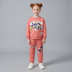 Niña vistiendo conjunto EmpiBy de dos piezas color coral con estampado de personajes Disney Friends y jogger a juego.