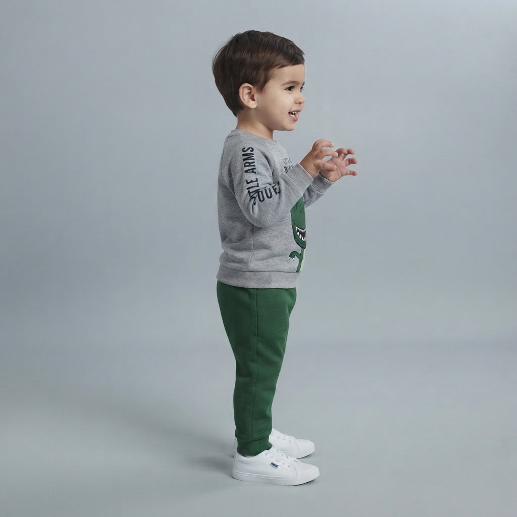 Niño vistiendo conjunto EmpiBy de sudadera gris con estampado de dinosaurio y pantalón verde cómodo