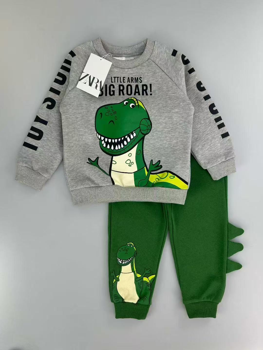 Conjunto EmpiBy de sudadera gris con estampado de dinosaurio y pantalón verde con detalles de púas en la pierna