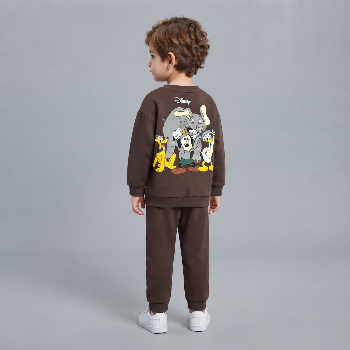 Niño de espaldas vistiendo conjunto EmpiBy de sudadera y pantalón marrón con estampado de personajes clásicos Disney