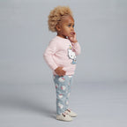 Niña pequeña vistiendo conjunto EmpiBy de suéter rosa con Hello Kitty y pantalón gris estampado de Hello Kitty