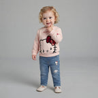 Niña pequeña vistiendo conjunto EmpiBy de sudadera rosa Hello Kitty con lentejuelas y jeans azules con parches