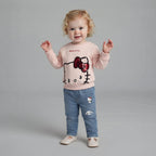 Niña pequeña con conjunto EmpiBy de sudadera rosa Hello Kitty con lentejuelas y jeans azules con parches bordados