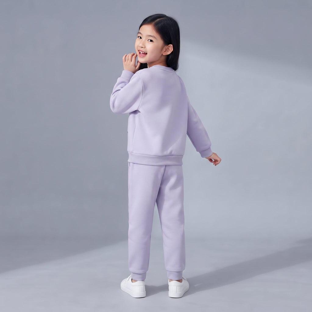 Niña vistiendo conjunto EmpiBy de dos piezas en color lila suave, sudadera y pantalón jogger, vista trasera