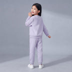 Niña vistiendo conjunto EmpiBy de dos piezas en color lila suave, sudadera y pantalón jogger, vista trasera