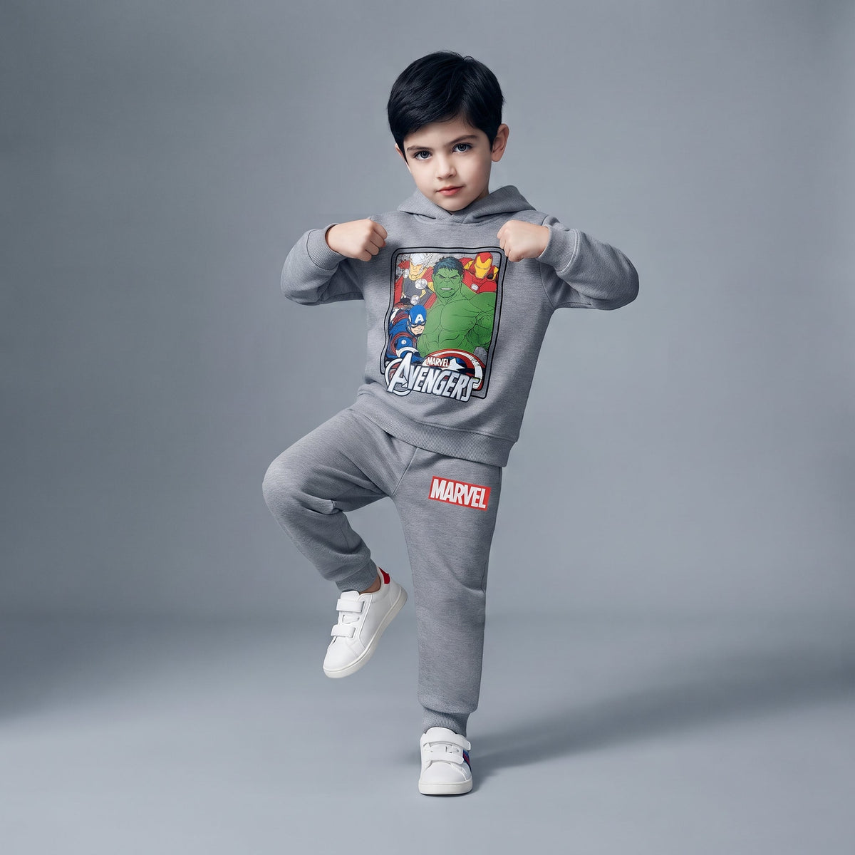 Niño posando con conjunto EmpiBy de sudadera y jogger gris de Marvel Avengers con estampado de superhéroes