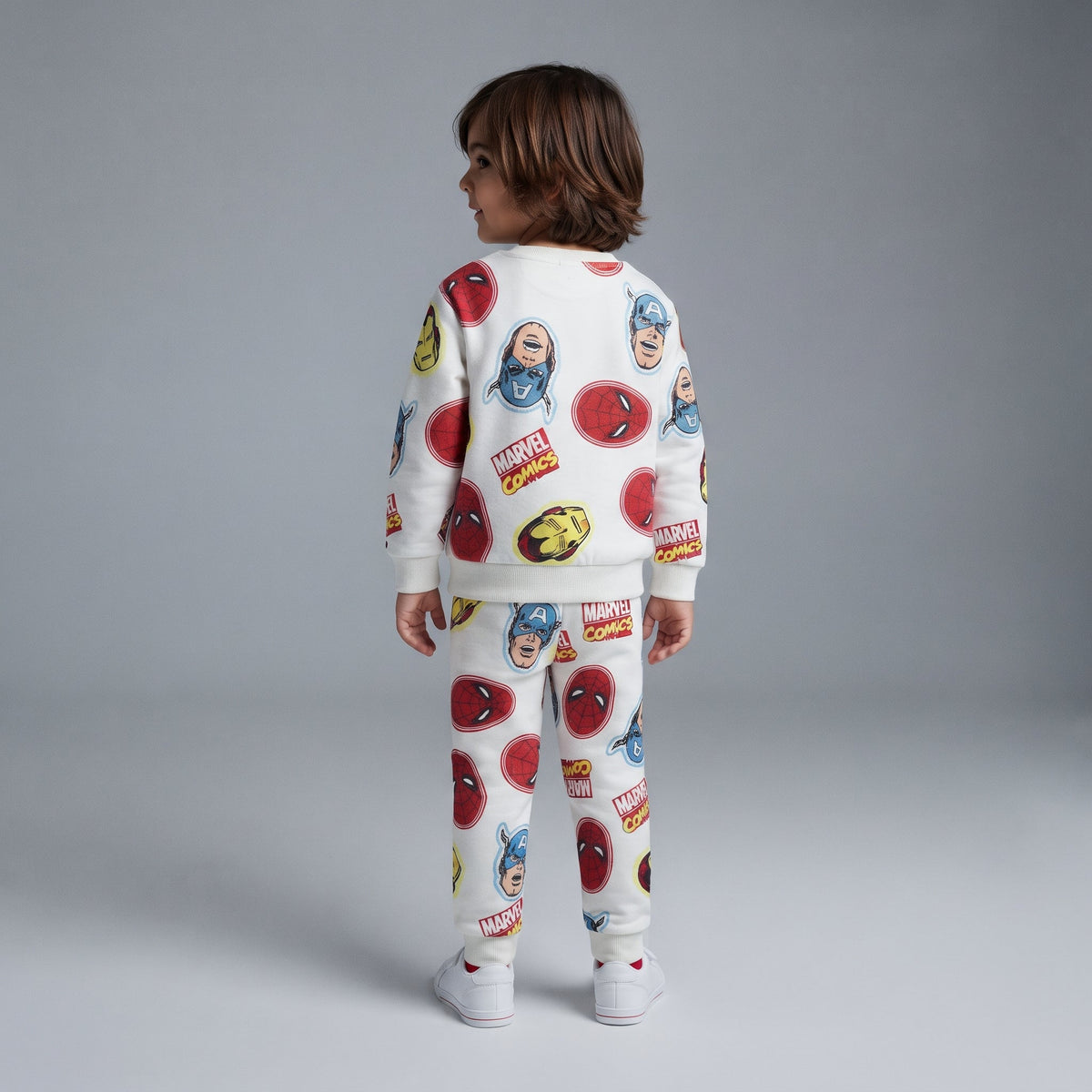 Niño de espaldas vistiendo conjunto EmpiBy de dos piezas Marvel en color marfil con estampado de superhéroes