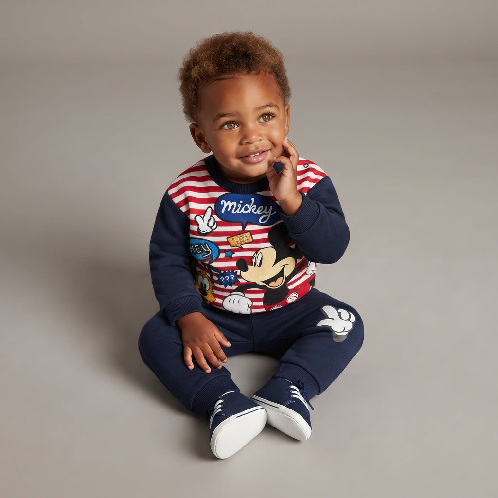 Bebé niño vistiendo conjunto EmpiBy de sudadera a rayas con Mickey Mouse y pantalón jogger azul marino