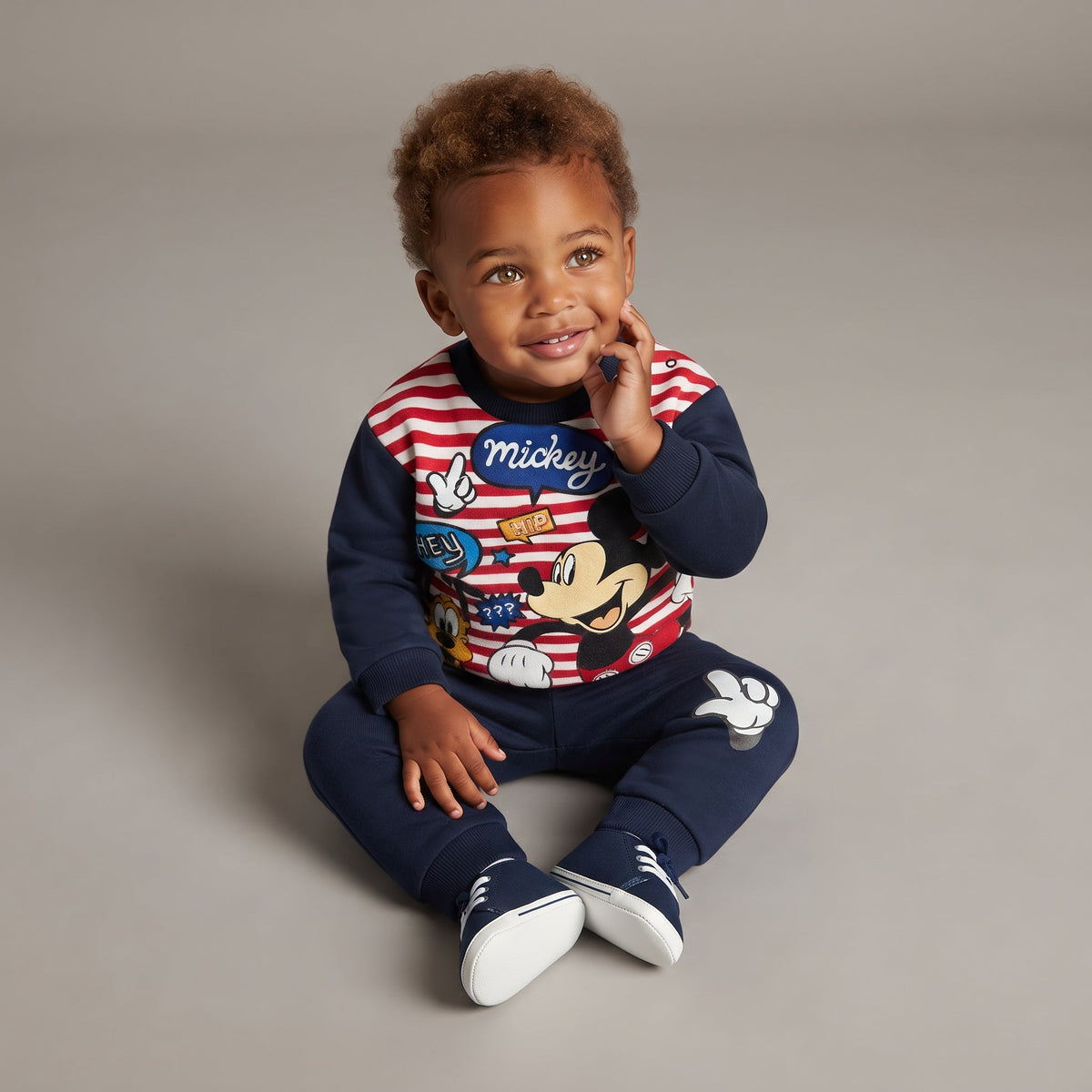 Bebé niño vistiendo conjunto EmpiBy de sudadera a rayas con Mickey Mouse y pantalón jogger azul marino