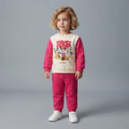 Niña pequeña vistiendo conjunto EmpiBy de sudadera crema y pantalón jogger fucsia con estampado de Mickey & Friends