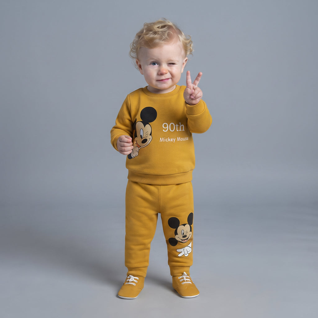 Bebé con conjunto EmpiBy de dos piezas color mostaza con estampado de Mickey Mouse conmemorativo de 90 años
