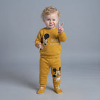 Bebé con conjunto EmpiBy de dos piezas color mostaza con estampado de Mickey Mouse conmemorativo de 90 años