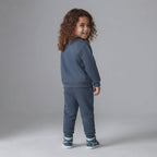 Niño pequeño vistiendo conjunto EmpiBy de sudadera y jogger azul oscuro con estampado de Mickey Mouse, vista trasera
