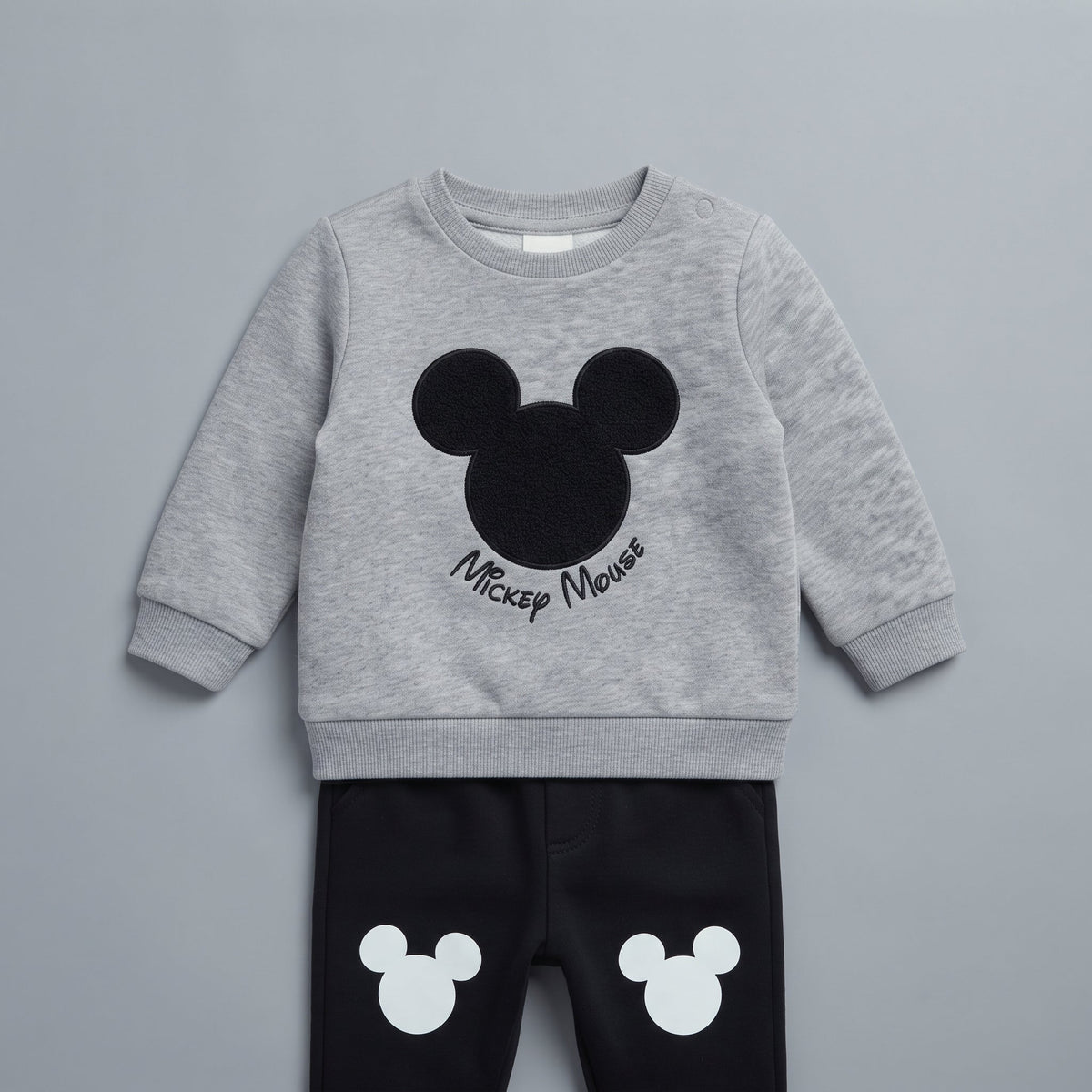 Conjunto EmpiBy de dos piezas para bebé con sudadera gris de Mickey Mouse y pantalón jogger negro con estampados