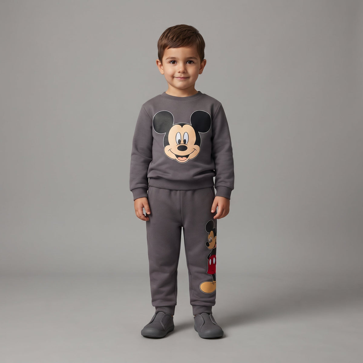 Niño vistiendo conjunto EmpiBy de dos piezas gris con estampado de Mickey Mouse, sudadera y pantalón tipo jogger.