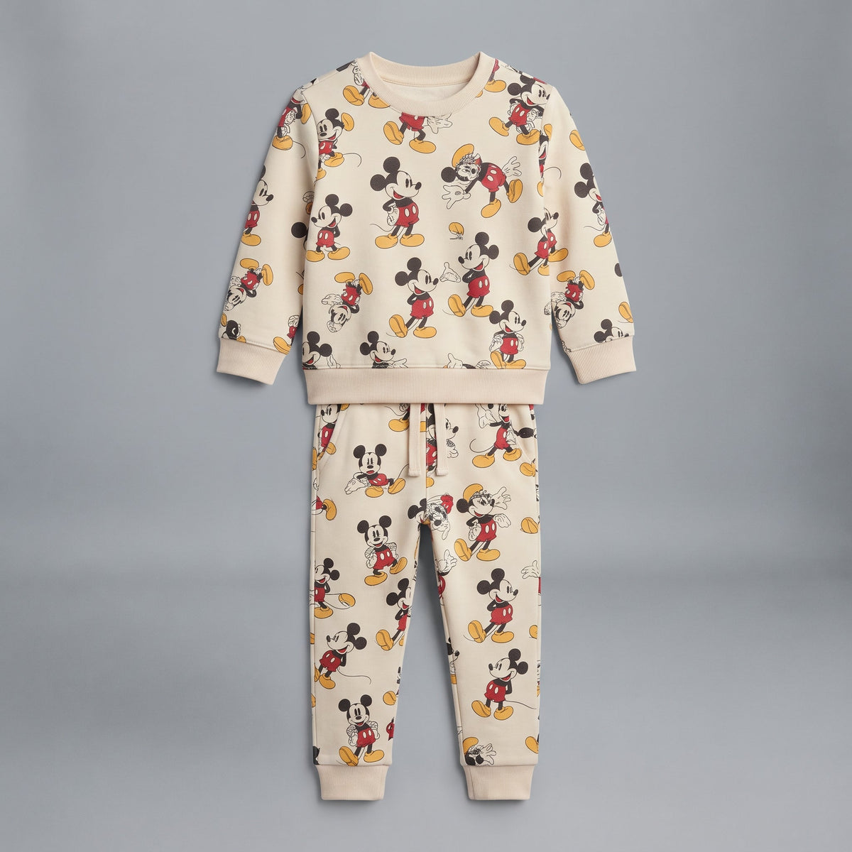 Conjunto EmpiBy de dos piezas para niño en color marfil con estampado integral de Mickey Mouse y tejido de felpa.