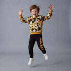 Niño saltando con conjunto EmpiBy de dos piezas de Mickey Mouse, sudadera estampada y pantalón jogger negro