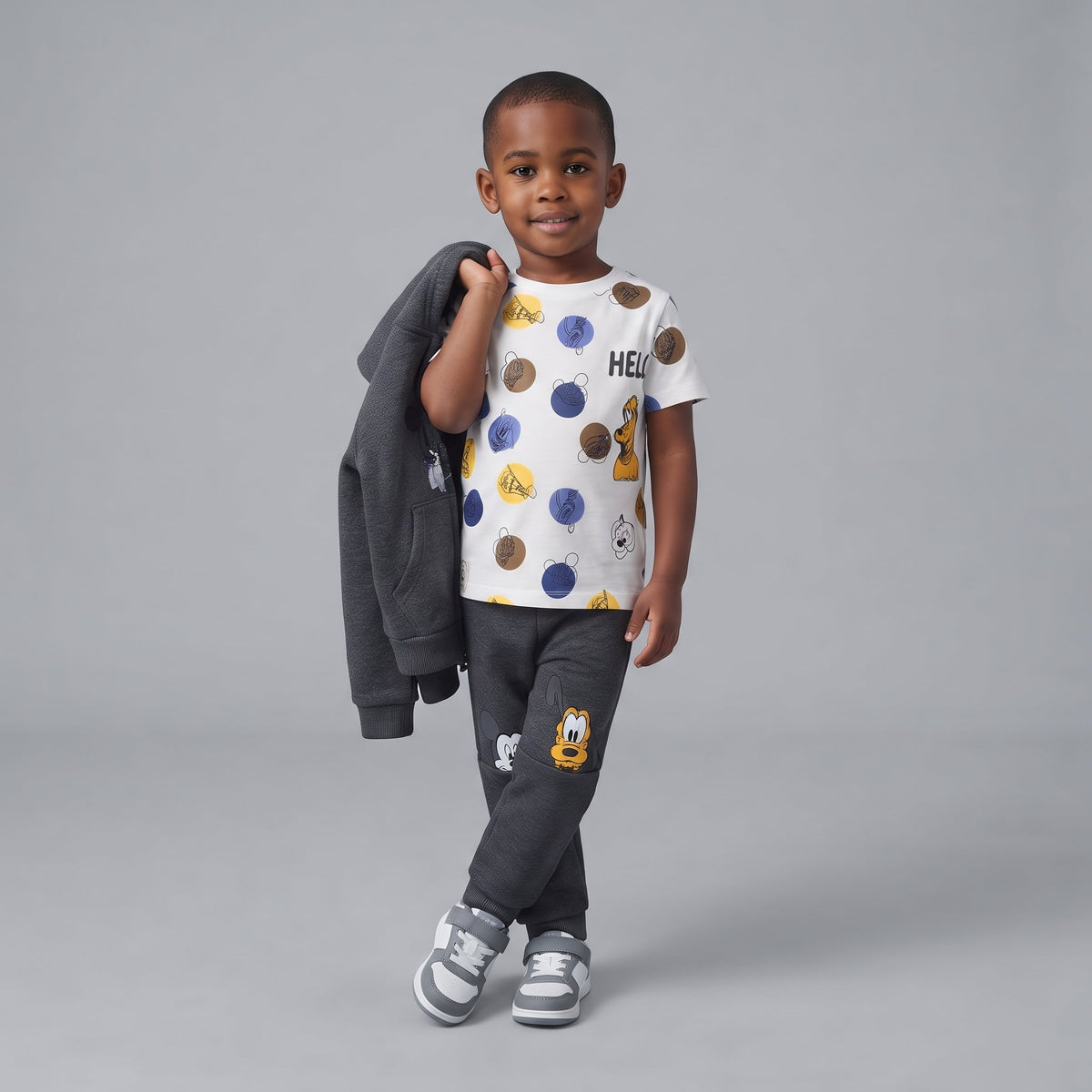Niño vistiendo conjunto EmpiBy de 3 piezas de Disney con sudadera gris, camiseta estampada y jogger con Mickey y Pluto