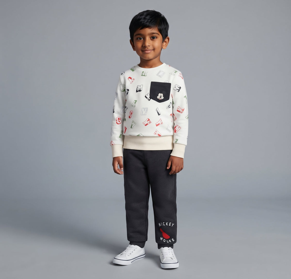 Niño vistiendo conjunto EmpiBy de buzo blanco con estampado de Mickey Mouse y pantalón gris oscuro con elástico