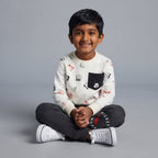 Niño sonriente vistiendo conjunto EmpiBy de buzo blanco con letras y Mickey Mouse y pantalón gris cómodo