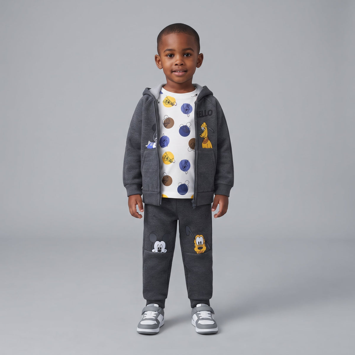 Niño vistiendo conjunto EmpiBy de 3 piezas Disney con sudadera gris, camiseta estampada y jogger con Mickey y Pluto